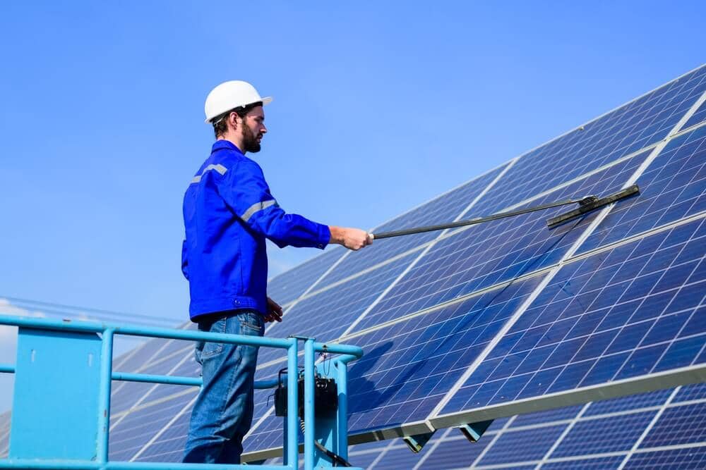 worker cleaning solar panels